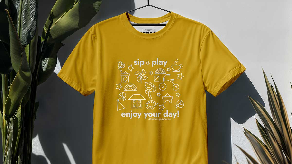 Yellow Tshirt with playful icons and "sip, play, enjoy your day!"