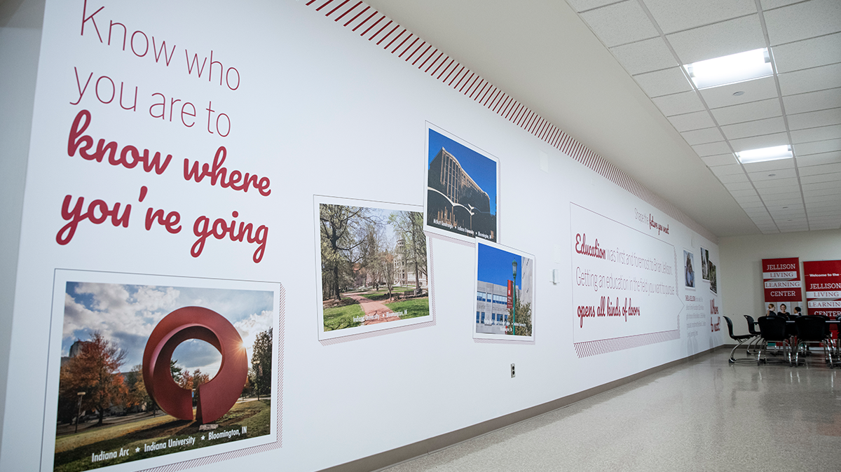 White wall with pinstripes and postcards with images of campus and Bloomington, Indiana