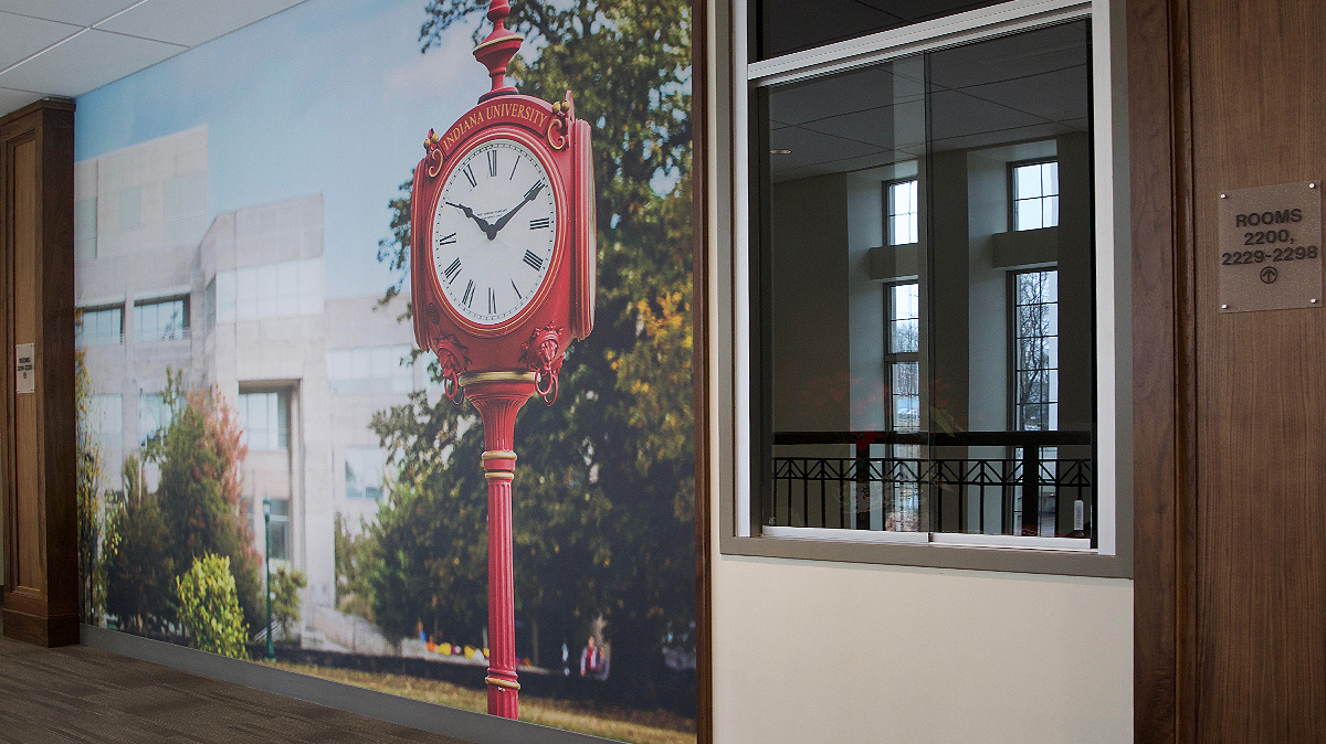 Conrad Prebys Wall Graphic with red clock in foreground and Kelley School of Business building in the background.