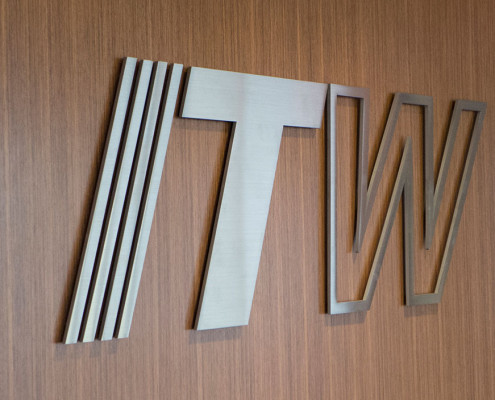 ITW metal logo on wood paneling