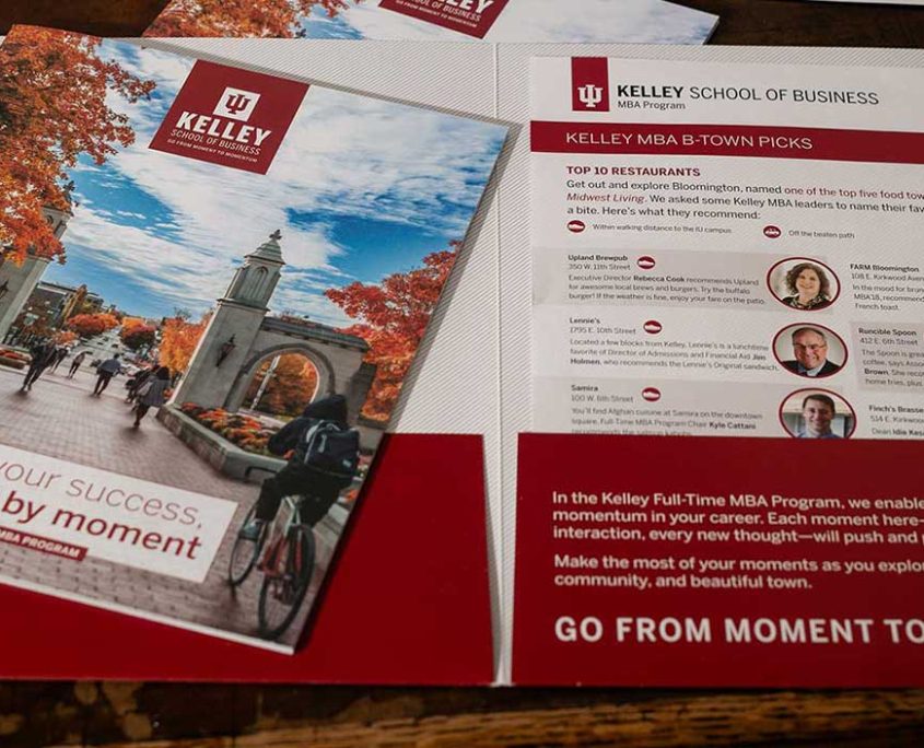 MBA folder opened on a desk, with a sheet inside about Bloomington Indiana favorite restaurants. The Full Time MBA viewbook is on top.