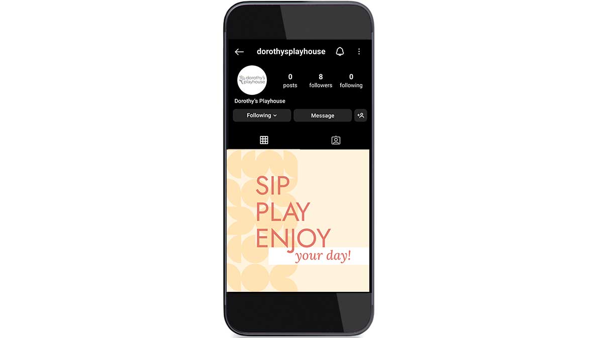 Cellphone showing Dorothy's Playhouse instagram post that says "Sip, Play, Enjoy your day"