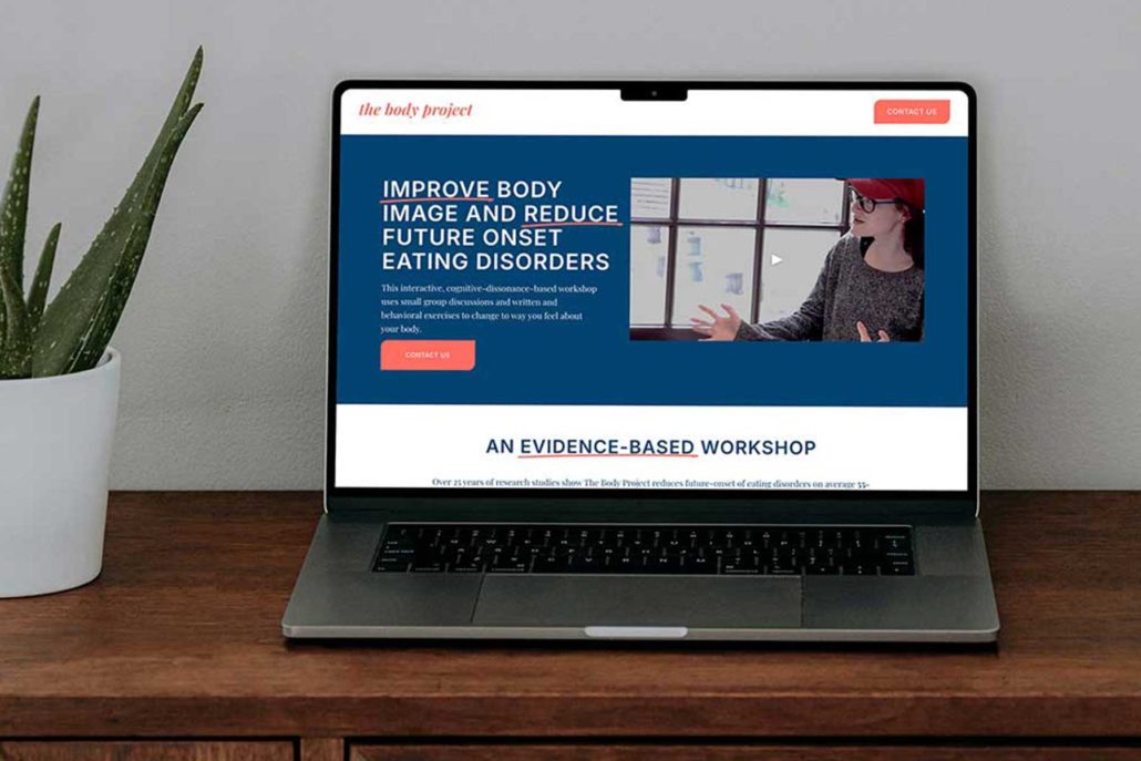 Computer sitting on credenza next to an aloe plant.